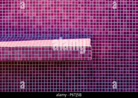 Colorful pink and purple tiled wall with tiled shelf Stock Photo