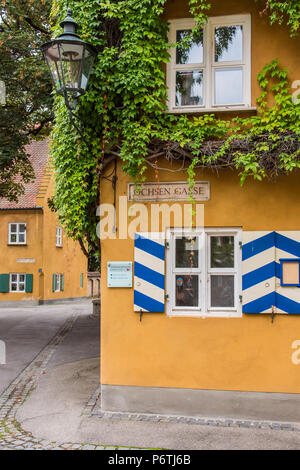 Street view of the Fuggerei settlemment, the world's oldest social housing complex still in use, Augsburg, Bavaria, Germany Stock Photo