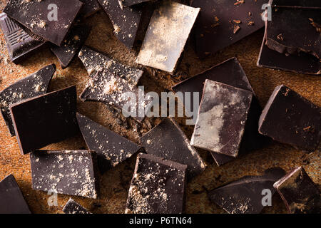 Broken chocolate pieces on brown background Stock Photo