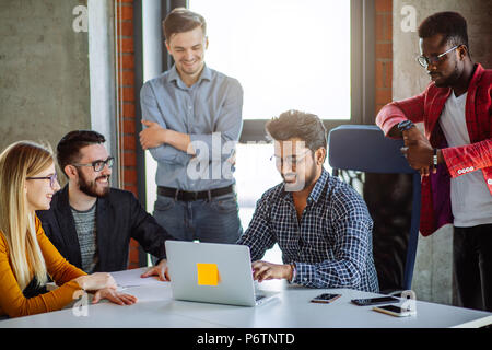 Successful start depends on good fresh idea and discipline. Young multi ethnic partners wearing casual bright clothes, discussing ideas for new strate Stock Photo
