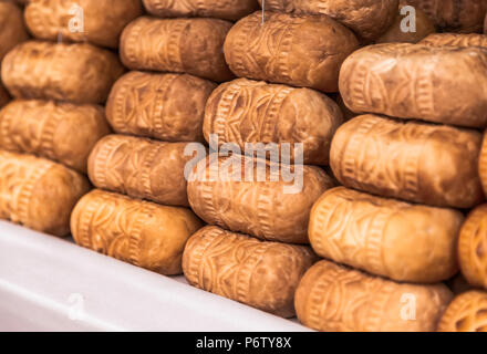 A symbol of the region Podhale in Poland - Oscypek cheeses on a counter of street shop in Zakopane Stock Photo