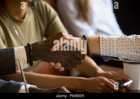 Multiracial handshake greeting during business meeting in cafe Stock Photo