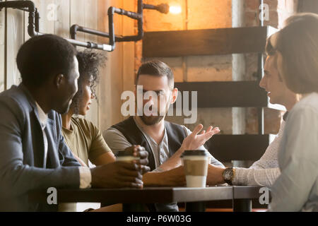 Multiracial colleagues discussing ideas during work break in caf Stock Photo