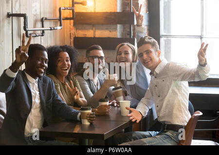 Smiling diverse millennial colleagues posing for picture in cafe Stock Photo