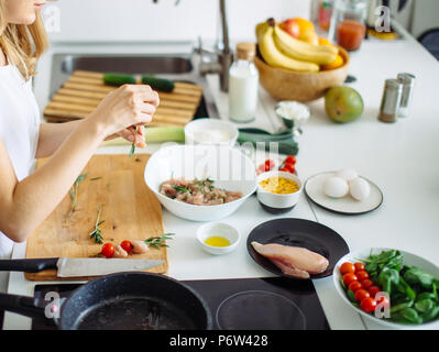 Cropped view of long-haired young woman preparing lunch for husband standing in modern, stylish kitchen. Healthy Home made Food Concept Stock Photo