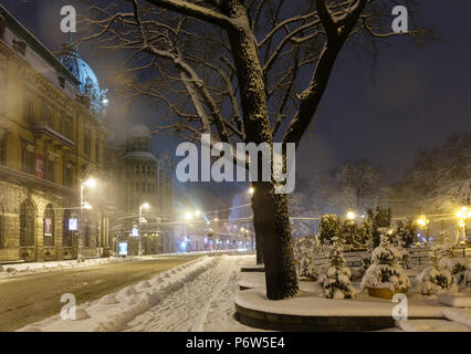 LVIV, UKRAINE - FEBRUARY 04, 2018: Beautiful night winter cityscape in the center of Lviv city. Some lens flare flrom lamps and snowflakes available. Stock Photo