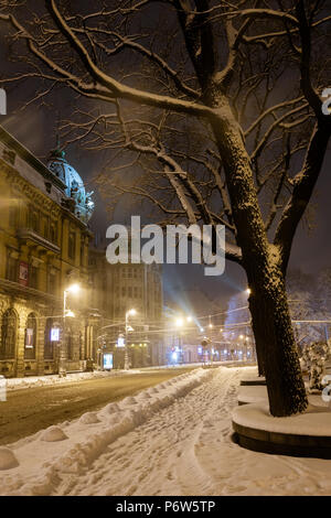 LVIV, UKRAINE - FEBRUARY 04, 2018: Beautiful night winter cityscape in the center of Lviv city. Some lens flare flrom lamps and snowflakes available. Stock Photo