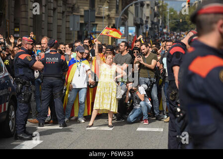 October 3, 2017 - Barcelona, Spain: Portrait of Maria de las Mercedes (C), a 65 yo Catalan opposed to the independence referendum, who showed up with a Spanish flag to show her support for Spanish unity as tens of thousands of pro-independence demonstrate against Madrid's rule during a general strike. Protesters marched by the Spanish national police headquarters, calling on Madrid to remove its 'occupation forces' two days after security forces intervened to prevent a Catalan independence referendum. Manifestation de masse des Catalans favorables a l'independance, deux jours apres le referend Stock Photo