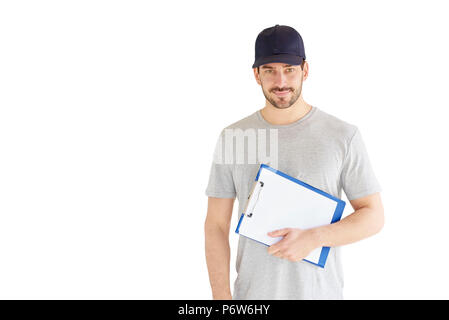 Portrait of handsome young man standing at isolated white background. Smiling carrying man wearing baseball cap and holding clipboard in his hand. Stock Photo