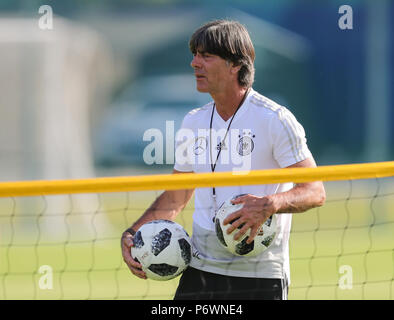 FILED - 25 June 2018, Russia, Watutinki: Soccer, World Cup 2018, German national team, team quarters. Head coach Joachim Loew holding two balls during training. According to information from the Newspaper 'Bild' and 'Sport Bild', Loew is going to carry on as coach despite the team going out of the world cup at the group stages. Both media outlets reported the new on Tuesdaym 03 July 2018. Photo: Christian Charisius/dpa Stock Photo