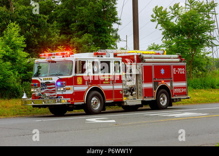 Sayreville NJ USA - Jujy 02, 2018: Firetruck driving flashing blue lights a accident damaged car on a road Stock Photo