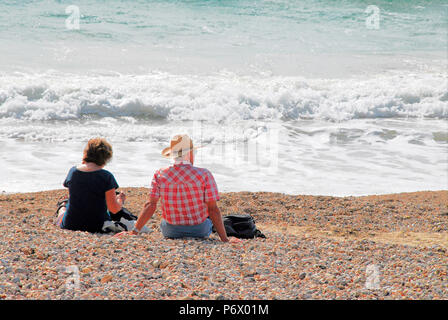 Weymouth. 3rd July 2018. An older couple relax in the early morning sunshine on Weymouth beach Credit: stuart fretwell/Alamy Live News Stock Photo