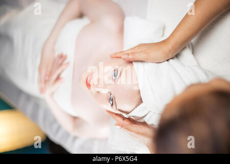 Adult european wealthy woman getting anti-aging face-lifting massage relaxing after working day. Stock Photo