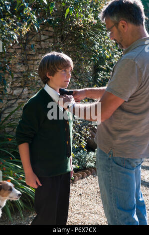 Father helping his son with his school tie Stock Photo