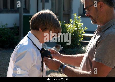 Father helping his son with his school tie Stock Photo