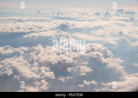 Skyline View above the Clouds from air plane. Go to vacation concept.Sunrise above clouds from airplane window.Panorama sky from altitude in the cumulus and layered stratus clouds. Stock Photo