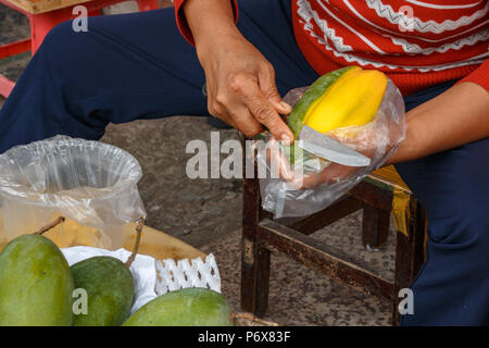Peeling and sharing the ripe yellow mango Stock Photo