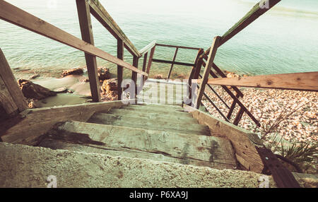 Perspective view of old wooden stairs down to beach. Zakynthos island, Greece. Vintage toned photo Stock Photo