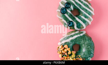 Donut topped spirulina glaze on pink Stock Photo