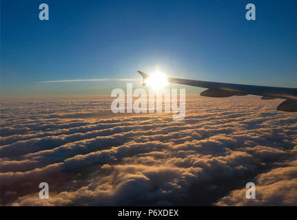 wing of airplane above the clouds Stock Photo