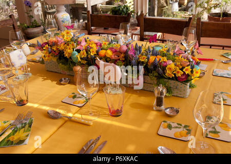 Dining table laid with beautiful spring flowers and Easter decorations Stock Photo