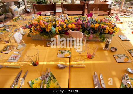 Dining table laid with beautiful spring flowers and Easter decorations Stock Photo