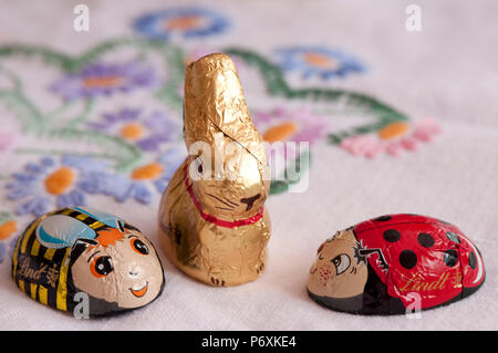 Little chocolate Easter bunnies and eggs on a pretty tablecloth Stock Photo