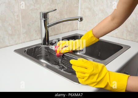 hands of woman cleaning sink in the kitchen Stock Photo