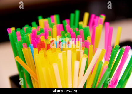Bright multicolored straws close-up on a blurred background. Stock Photo