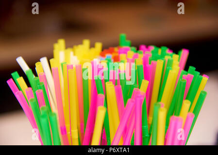 Bright multicolored straws close-up on a blurred background. Stock Photo
