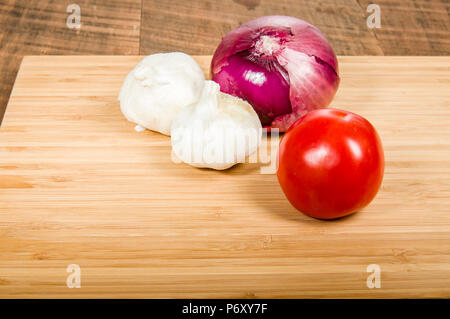 Tomato with cloves of garlic and a red onion Stock Photo - Alamy