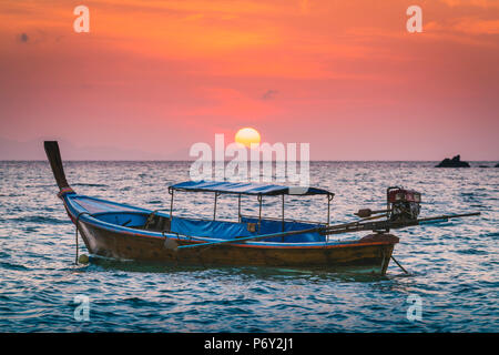 Longtail boats at Sunset Beach, Ko Lipe, Satun Province, Thailand. Traditional long tail boat and rising sun. Stock Photo