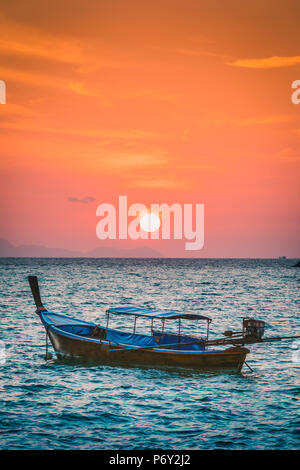 Longtail boats at Sunset Beach, Ko Lipe, Satun Province, Thailand. Traditional long tail boat and rising sun. Stock Photo