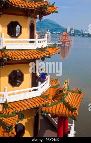 Taiwan, Kaohsiung, Lotus pond, Dragon and Tiger Tower Temple with view of bridge leading to Spring and Autumn pagodas and statue of Syuan Tian Emperor in background Stock Photo