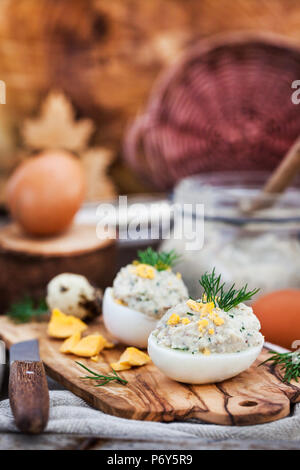 Eggs stuffed with herring creamy pate on wooden rustic background Stock Photo