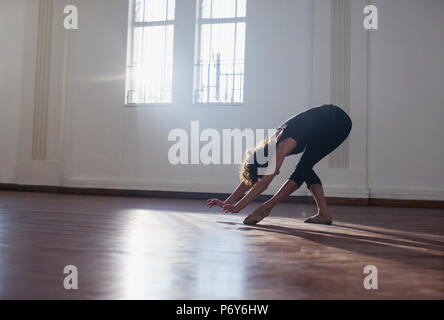 Graceful young female dancer practicing in dance studio Stock Photo