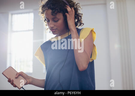 Young female dancer listening to music with headphones and mp3 player Stock Photo