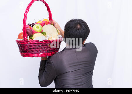 Business man holding basket group fruit on white background, Stock Photo