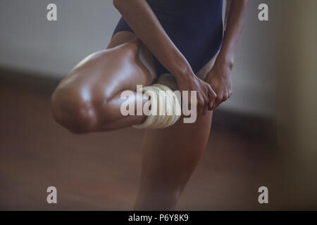 Strong, young female dancer stretching leg Stock Photo