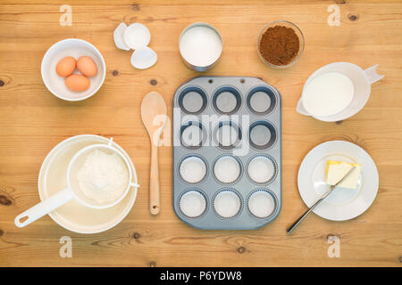 Overhead flat lay arrangement of Cup Cake making ingredients and equipment on a kitchen table. Stock Photo