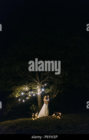 The wedding ceremony at night. Lighting candles on the grass. Stock Photo