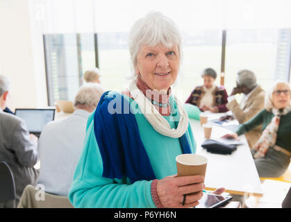 Portrait confident senior businesswoman drinking coffee in meeting Stock Photo
