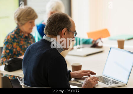 Senior businessman using laptop in meeting Stock Photo