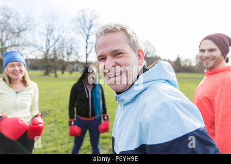 Portrait smiling, confident man boxing with friends in park Stock Photo