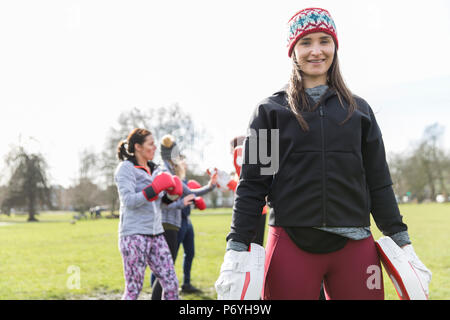 Portrait confident young woman boxing in park Stock Photo