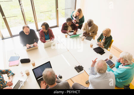 Senior business people using laptops and digital tablets in conference room meeting Stock Photo