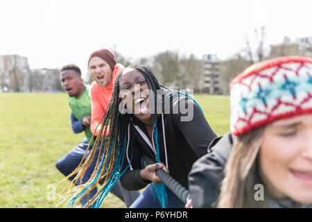 Determined team pulling rope in tug-of-war Stock Photo