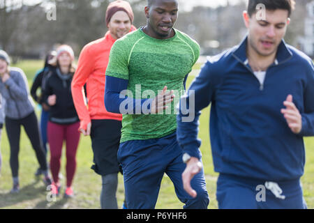 Focused men exercising, doing drill in park Stock Photo