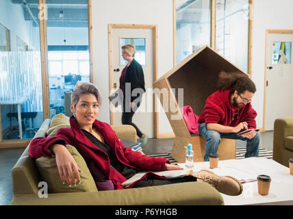 Portrait confident creative businesswoman working in open plan office Stock Photo