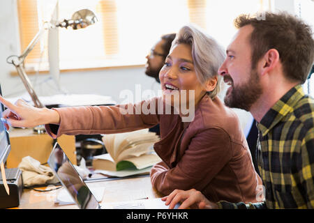 Smiling creative business people meeting, working at computer in office Stock Photo